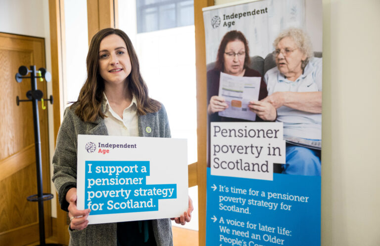 Debbie Horne of Independent Age holding a photo board that says 'I support a pensioner poverty strategy for Scotland'