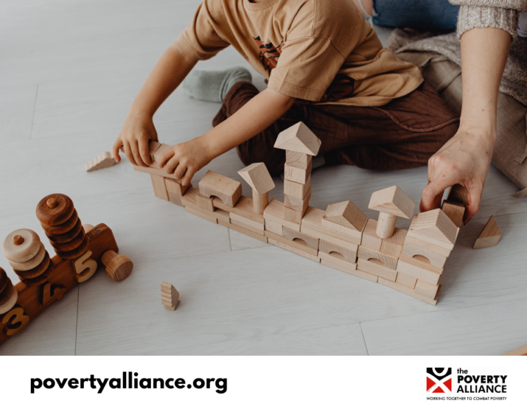 A stock image featuring the hands of a young boy and his father, building a town out of wooden blocks.